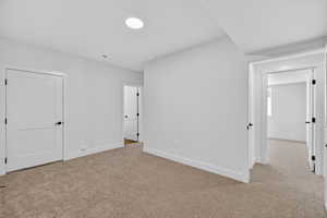 Unfurnished bedroom with light carpet