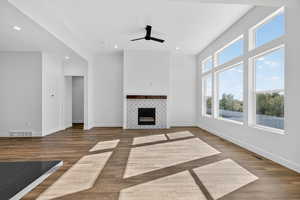 Unfurnished living room featuring dark wood finished floors, recessed lighting, a fireplace, and ceiling fan