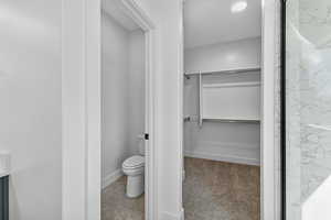 Full bathroom with a spacious closet, vanity, light carpet, and light tile patterned flooring