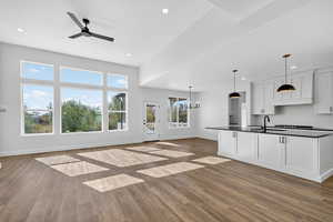 Unfurnished living room featuring a chandelier, ceiling fan, recessed lighting, and dark wood-style flooring