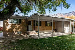 Back of property with a patio area, brick siding, and a mountain view