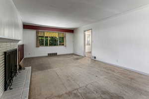 Unfurnished living room with crown molding, carpet floors, and a fireplace