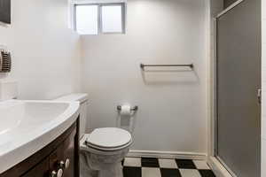 Full bathroom with dark floors, a stall shower, and vanity
