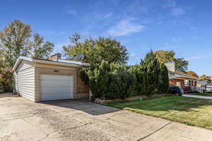 View of front of property with driveway, a garage, a front lawn, and a chimney