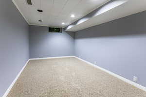Finished basement featuring baseboards and a paneled ceiling