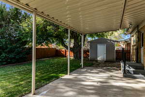 Fenced backyard with a patio and a shed