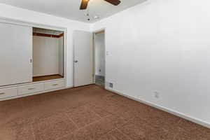 Unfurnished bedroom featuring a closet, carpet floors, and ceiling fan