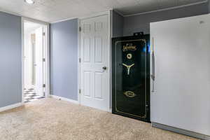 Unfurnished bedroom with freestanding refrigerator and carpet flooring