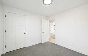 Unfurnished bedroom with carpet and baseboards