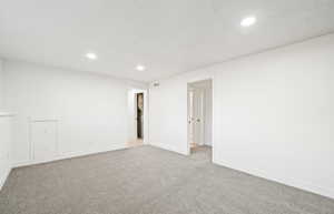Unfurnished room with carpet floors, recessed lighting, and a textured ceiling