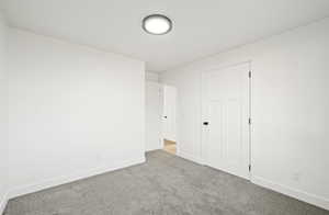 Unfurnished bedroom featuring carpet floors and baseboards
