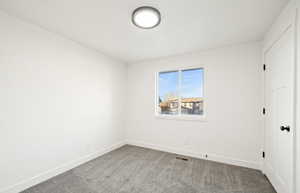 Carpeted empty room featuring baseboards