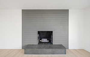 Detailed view of wood finished floors and a fireplace with raised hearth