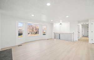 Unfurnished room featuring light wood-style floors, recessed lighting, and a textured ceiling