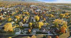 Aerial view of property and surrounding area featuring nearby suburban area