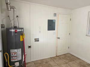 Utility room featuring gas water heater and electric panel