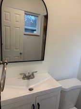 Half bathroom featuring vanity and toilet