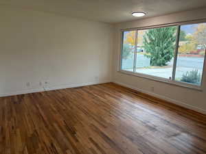 Unfurnished room with wood finished floors and baseboards