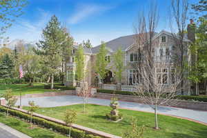 View of front of house with a front lawn, stone siding, and a chimney