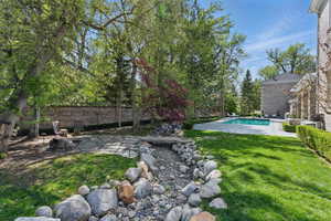 Fenced yard featuring a patio area and view of scattered trees