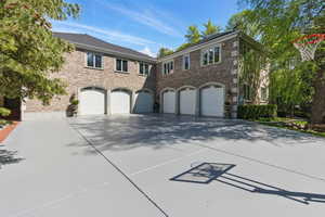 View of front of property featuring driveway, a garage, and brick siding