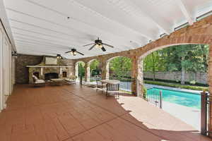 View of patio / terrace featuring an outdoor pool, a ceiling fan, and an outdoor stone fireplace