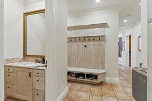 Mudroom with light tile patterned floors, crown molding, and recessed lighting