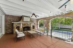 View of patio / terrace with a ceiling fan, an outdoor living space with a fireplace, and an outdoor pool