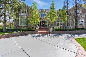 French country style house featuring french doors, a balcony, and brick siding
