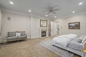 Bedroom featuring ornamental molding, carpet floors, recessed lighting, a fireplace with flush hearth, and a ceiling fan