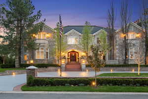 French country home featuring stone siding and a balcony