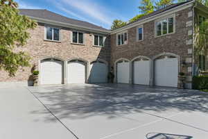 View of front facade featuring a garage, concrete driveway, and brick siding