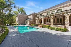 Swimming pool featuring a ceiling fan and a patio area