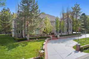 View of front of house with a front lawn and stone siding