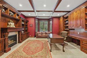 Office featuring built in study area, beam ceiling, recessed lighting, coffered ceiling, and a fireplace with flush hearth