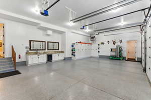Garage featuring beverage cooler, a heating unit, and a garage door opener