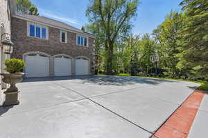 View of side of home with driveway, an attached garage, and brick siding