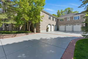 View of front of property featuring driveway, an attached garage, and brick siding