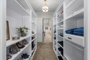 Spacious closet featuring light colored carpet