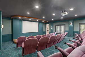 Carpeted home theater featuring a wainscoted wall and recessed lighting