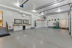 Garage featuring a heating unit, wine cooler, and a garage door opener