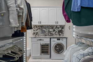 Laundry room with washer / clothes dryer, beverage cooler, light tile patterned floors, and cabinet space