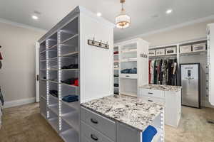 Spacious closet featuring light colored carpet