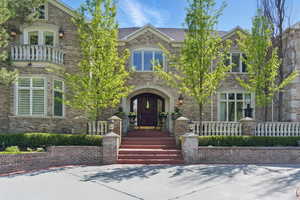 View of front of property with brick siding and a balcony