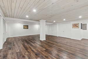 Below grade area with wooden ceiling, dark wood-style flooring, and recessed lighting