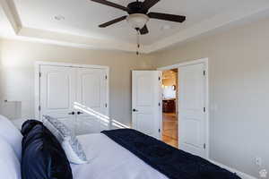 Bedroom featuring a raised ceiling, a ceiling fan, a closet, and recessed lighting