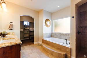 Bathroom with a garden tub, double vanity, a tile shower, recessed lighting, and light tile patterned floors