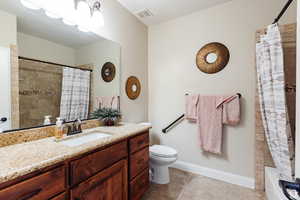 Bathroom featuring vanity, light tile patterned floors, and shower / tub combo with curtain