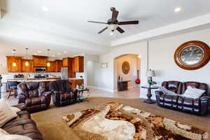 Living room featuring light carpet, recessed lighting, arched walkways, and ceiling fan