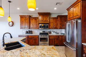 Kitchen with stainless steel appliances, light stone counters, backsplash, and recessed lighting